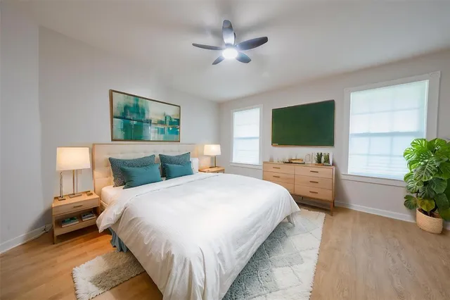 a bedroom with bed a flat tv and a potted plant