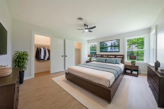 a bedroom with a large bed and potted plant