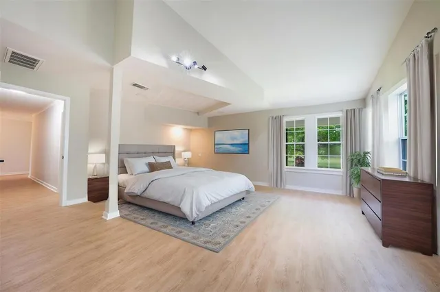 a spacious bedroom with a large bed and a large window