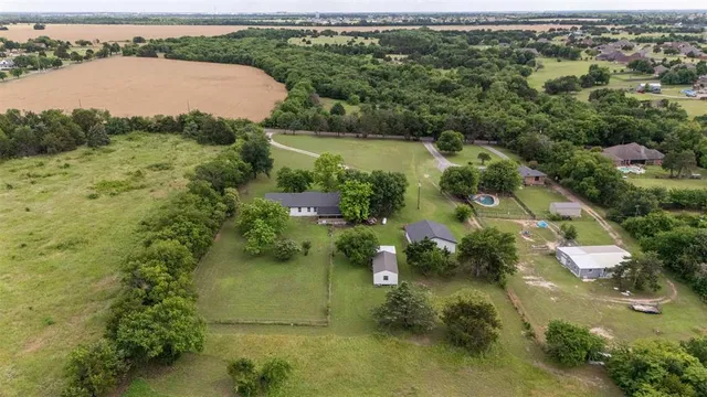 an aerial view of residential houses with outdoor space and lake view