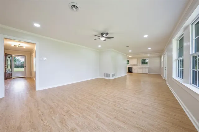 a view of empty room with wooden floor and ceiling fan