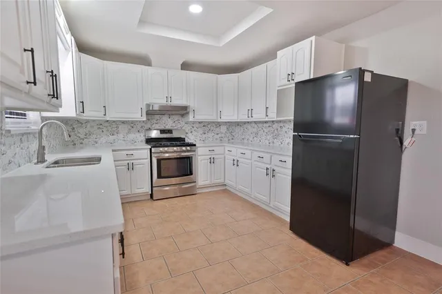 a kitchen with a refrigerator sink and cabinets