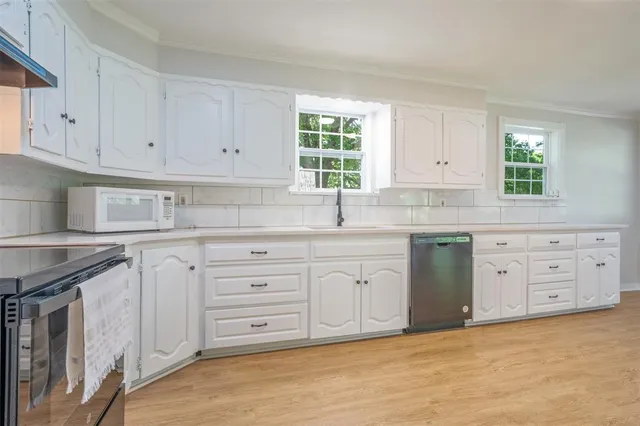 a kitchen with cabinets appliances a window and a sink