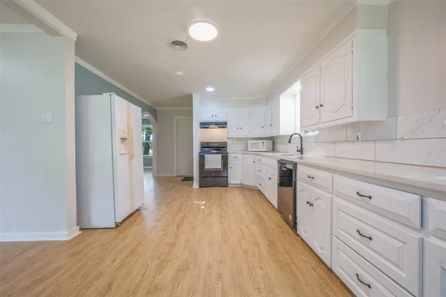 a kitchen with cabinets and wooden floor