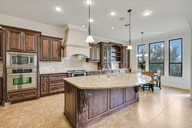 a large kitchen with kitchen island a stove a sink a dining table and chairs