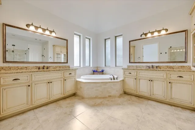 a spacious bathroom with a shower tub double sink and mirror
