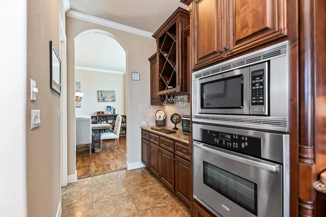 a kitchen with stainless steel appliances granite countertop a stove a sink and a microwave