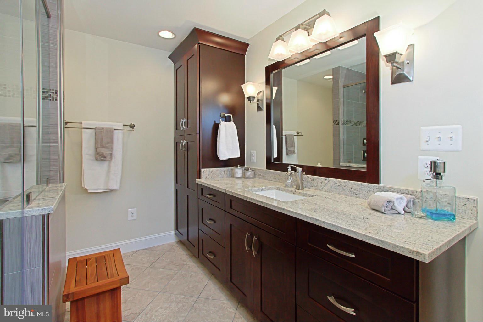 8548 Bauer Circle Springfield, VA 22152 - Photo 23 of 30 a bathroom with a granite countertop sink and a mirror