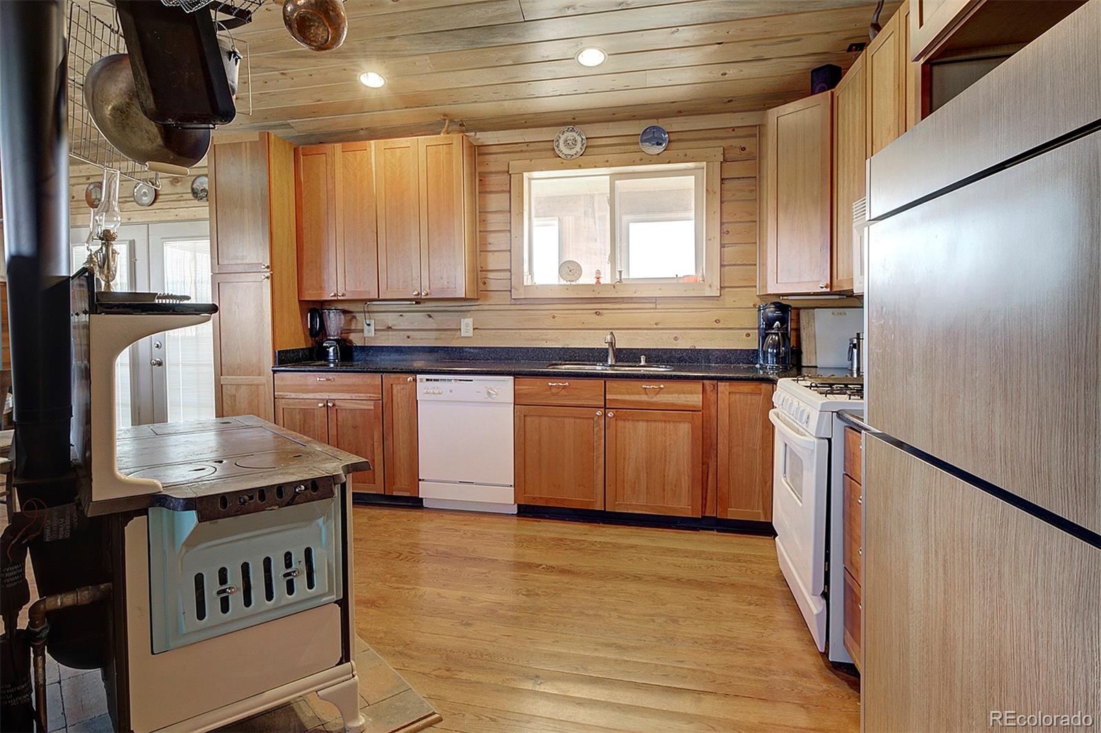 2005 Cahokia Road Hartsel, CO 80449 - Photo 20 of 42 a kitchen with stainless steel appliances granite countertop a sink a stove and a wooden floor