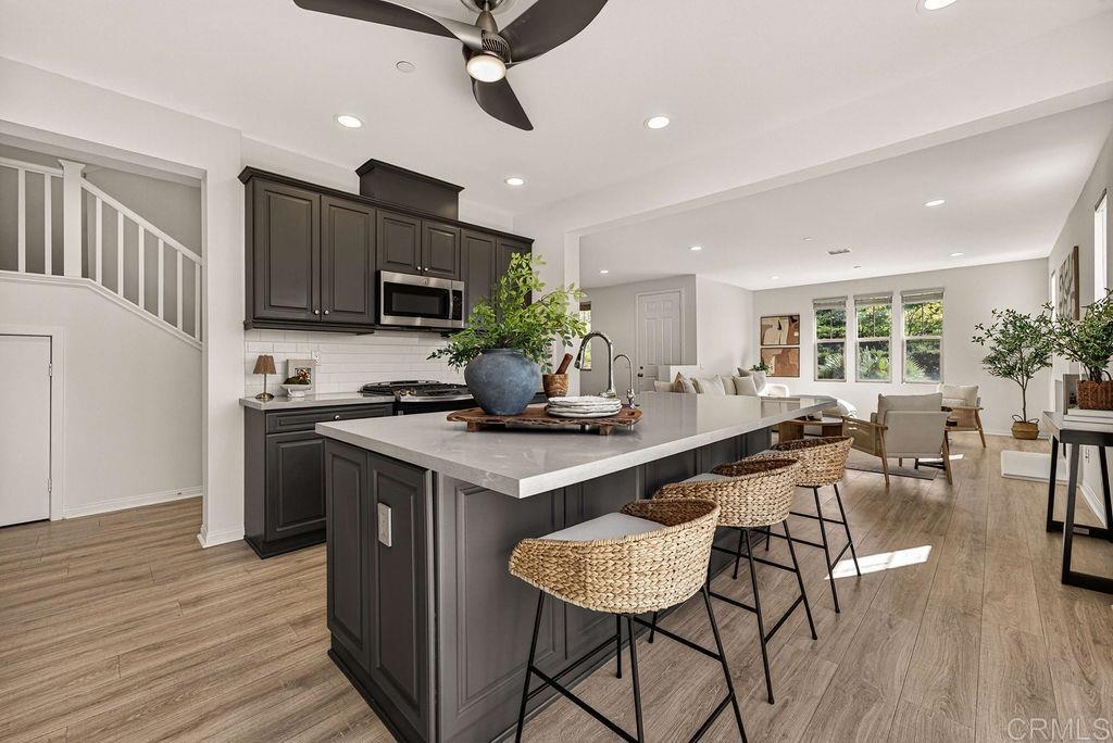 4301 Pacifica Way, Unit 2 Oceanside, CA 92056 - Photo 3 of 47 a kitchen with stainless steel appliances granite countertop a stove top oven a sink dishwasher a dining table and chairs with wooden floor