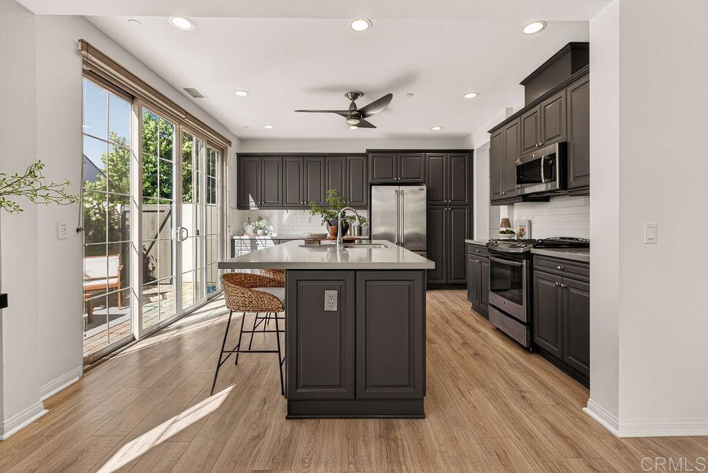 4301 Pacifica Way, Unit 2 Oceanside, CA 92056 - Photo 9 of 47 a kitchen with stainless steel appliances granite countertop a refrigerator a sink dishwasher a stove and a microwave oven with wooden floor