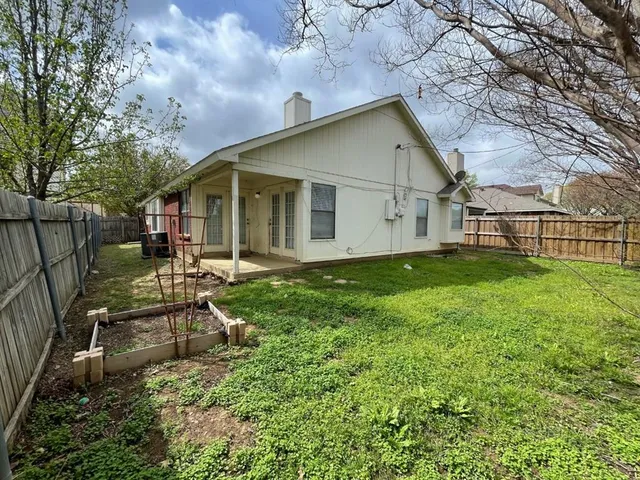 a backyard of a house with table and chairs