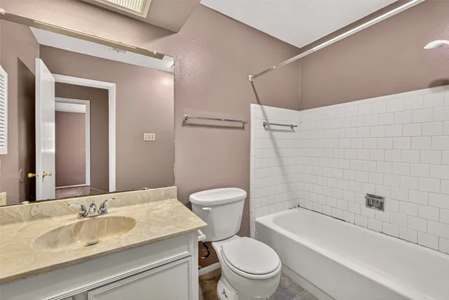 a bathroom with a granite countertop toilet a sink and a bathtub