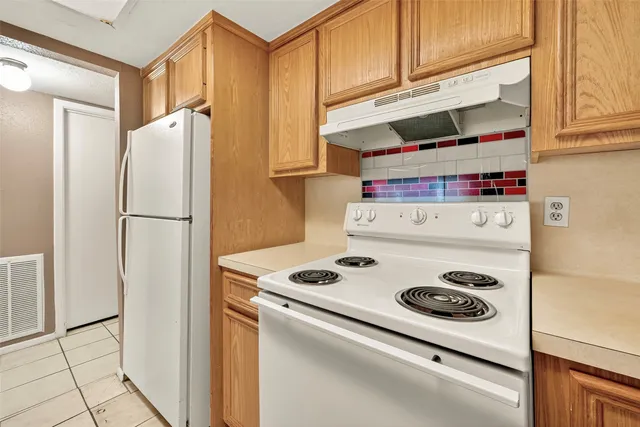 a kitchen with a refrigerator and a stove