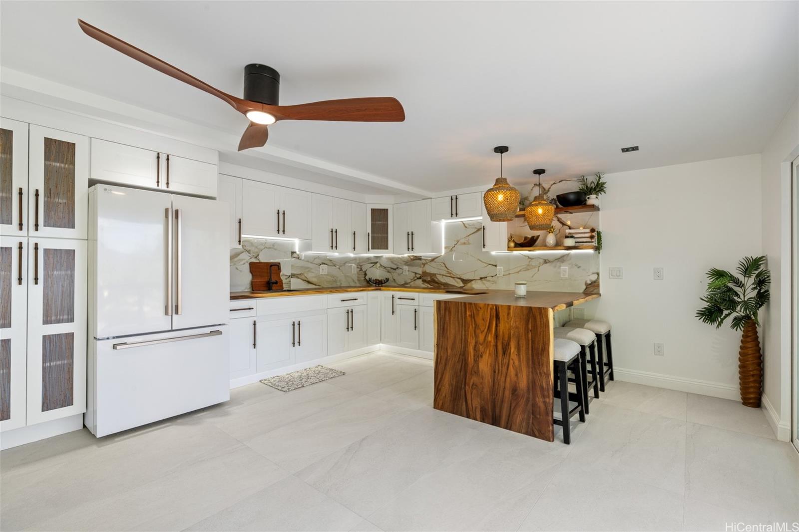 852 Kainoa Place Honolulu, HI 96821 - Photo 16 of 25 a kitchen with stainless steel appliances granite countertop a refrigerator a sink dishwasher and white cabinets with wooden floor