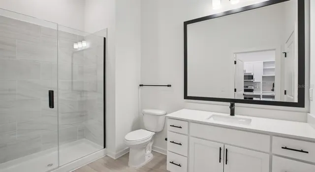 a bathroom with a sink a toilet and shower