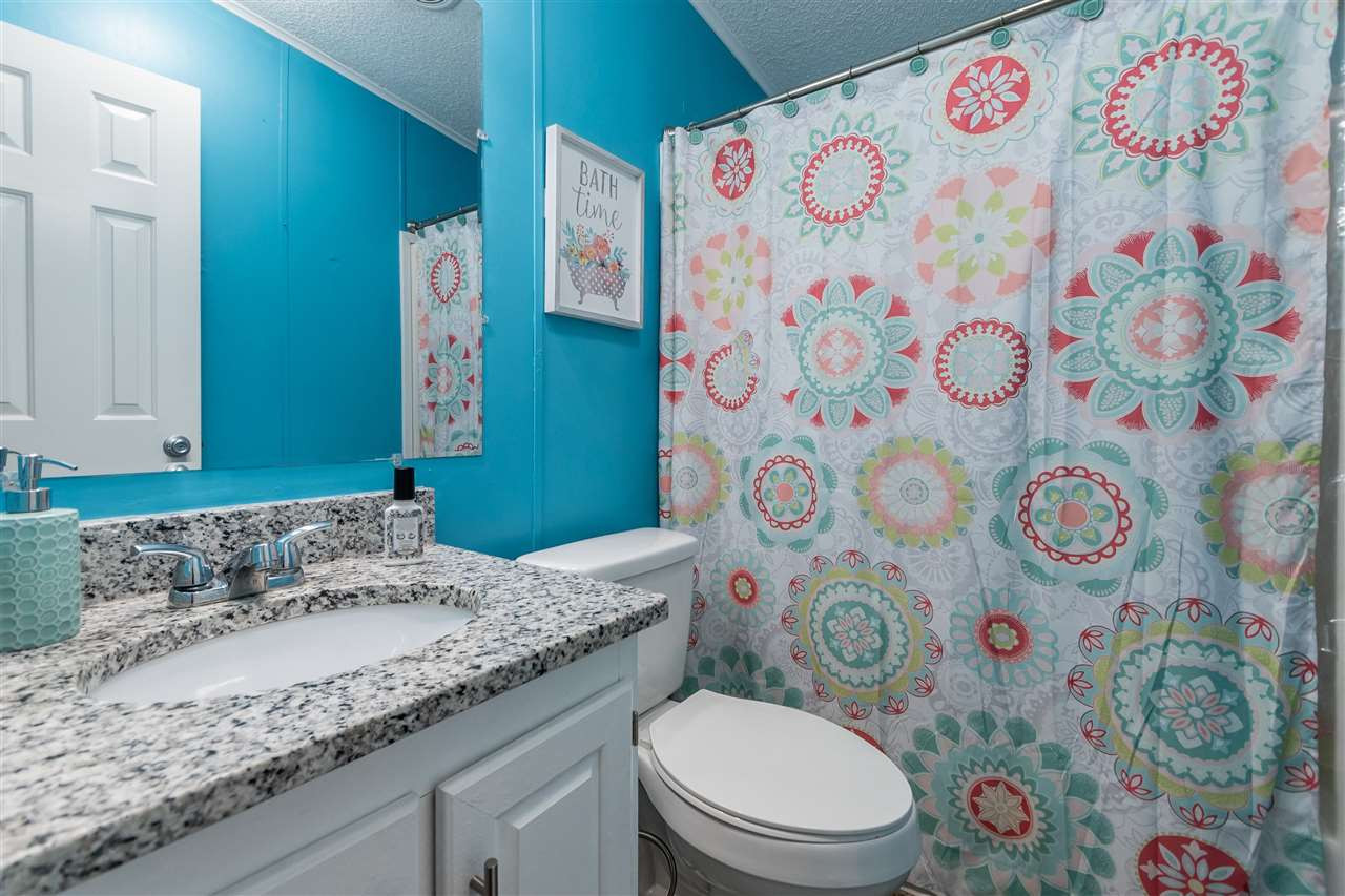 8409 Creek Road Willow Spring, NC 27592 - Photo 24 of 27 a bathroom with a granite countertop toilet sink and mirror