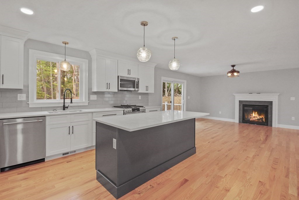 529 Chadwick Road Haverhill, MA 01835 - Photo 13 of 38 a kitchen with stainless steel appliances granite countertop a sink a stove and a wooden floors