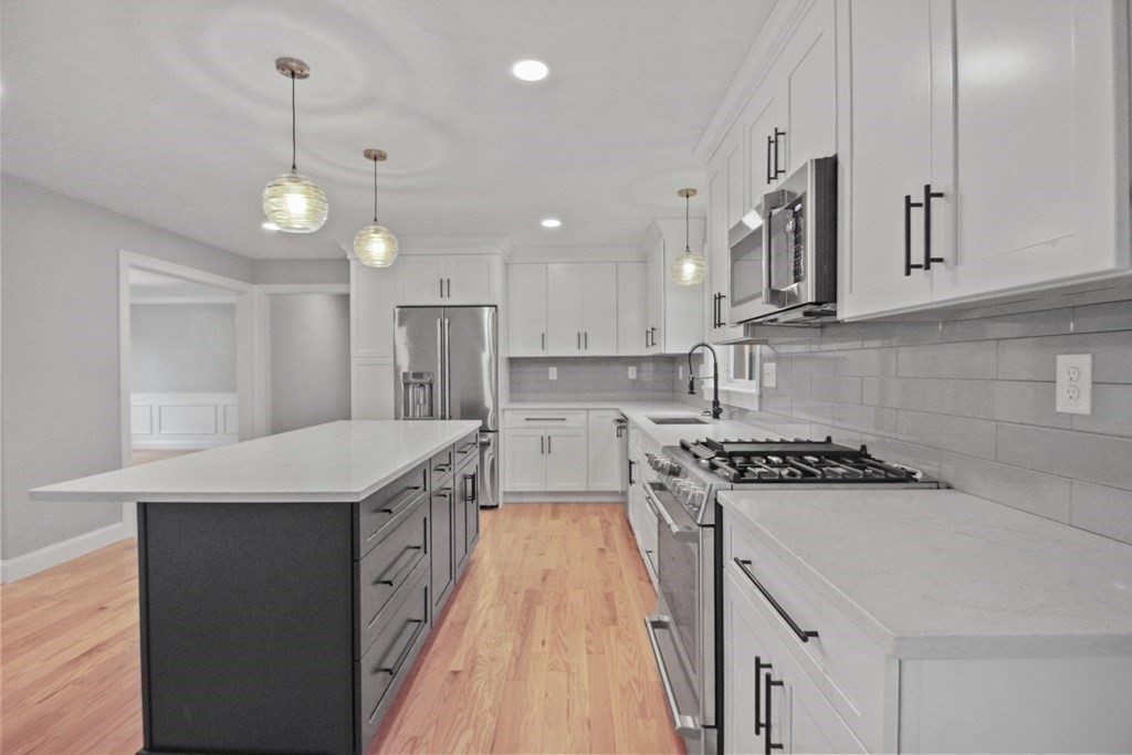 529 Chadwick Road Haverhill, MA 01835 - Photo 8 of 38 a kitchen with stainless steel appliances granite countertop a sink a stove and a refrigerator