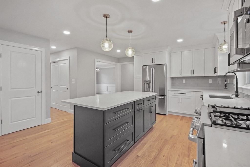 529 Chadwick Road Haverhill, MA 01835 - Photo 10 of 38 a kitchen with stainless steel appliances granite countertop a sink a stove a refrigerator and white cabinets with wooden floor