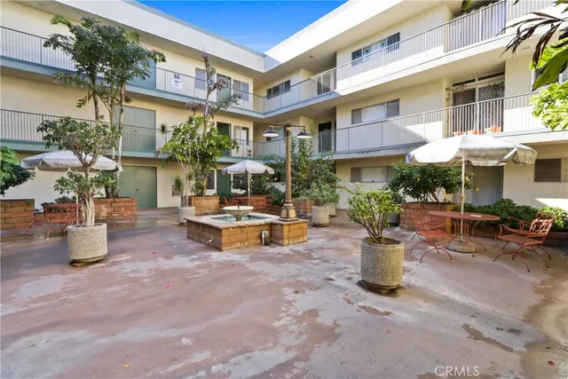 a view of a building with sitting area and potted plants
