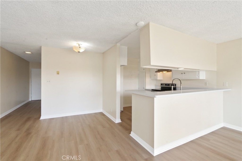 1187 East 3rd Street, Unit 215 Long Beach, CA 90802 - Photo 4 of 15 a kitchen with a refrigerator and a stove top oven