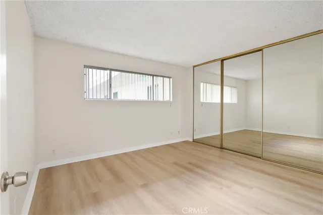 a view of an empty room with window and closet area