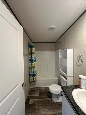 a bathroom with a granite countertop sink toilet a mirror and shower