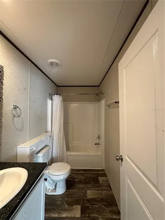 a bathroom with a granite countertop sink toilet a mirror and shower