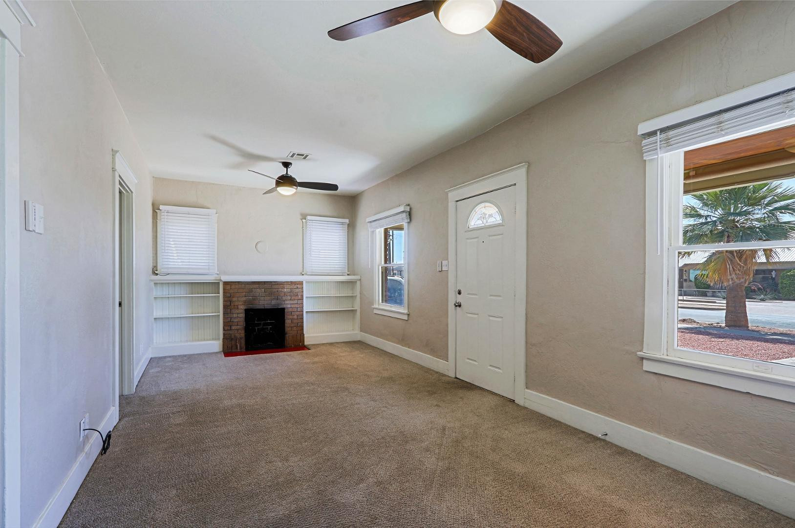 841 North 9th Avenue Phoenix, AZ 85007 - Photo 5 of 21 an empty room with windows fireplace and a ceiling fan