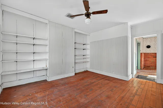 a view of empty room with wooden floor and cabinet