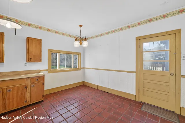 a view of an empty room with window and cabinet