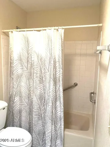 a view of an empty room and chandelier fan