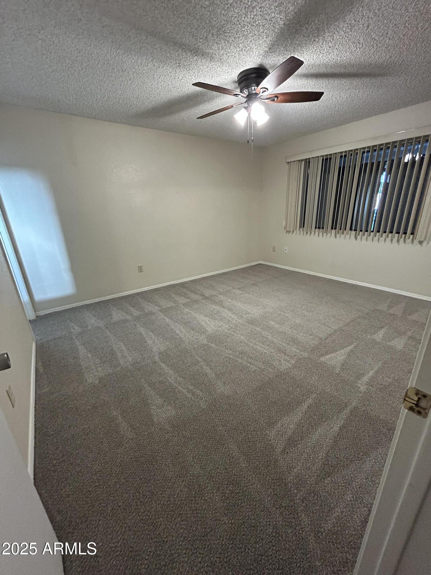 1021 South Greenfield Road, Unit 1198 Mesa, AZ 85206 - Photo 17 of 29 a view of an empty room and chandelier fan