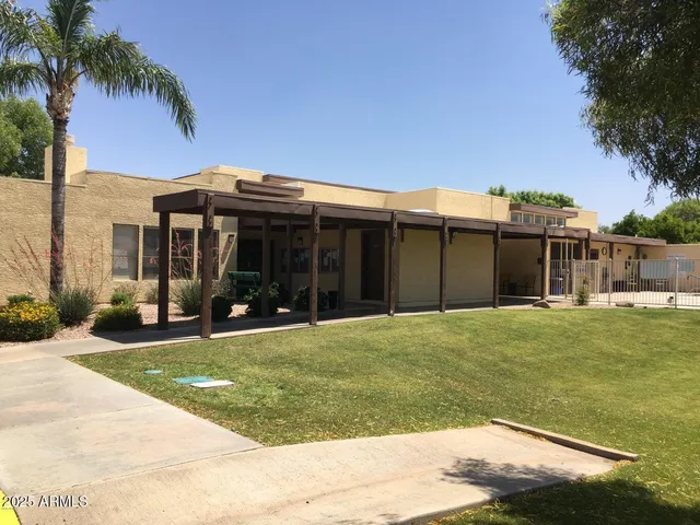 a view of a tennis ground with large trees