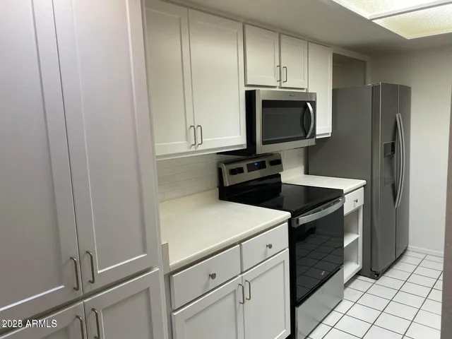 a kitchen with white cabinets and a sink