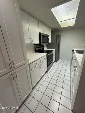 a kitchen with a sink and white cabinets