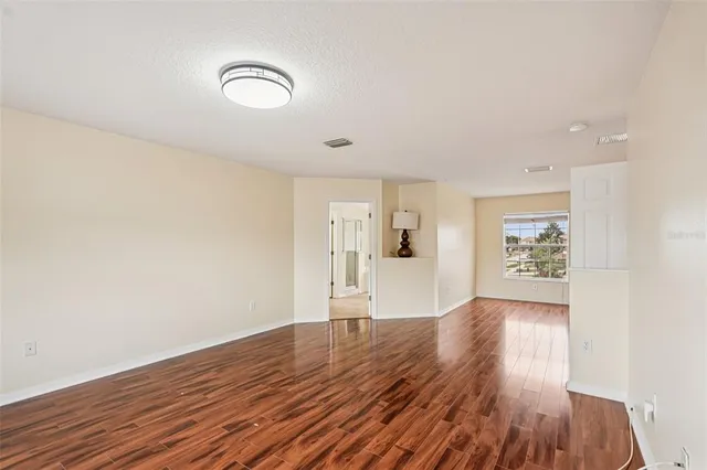 a view of empty room with wooden floor