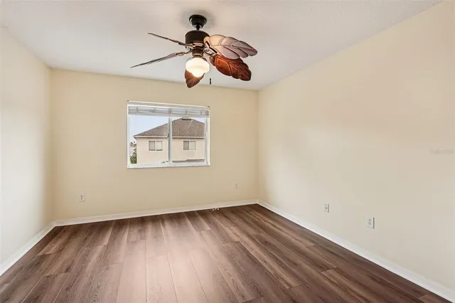 a view of room with hardwood floor and ceiling fan