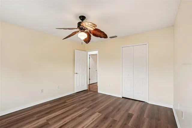 a view of a room with wooden floor and ceiling fan