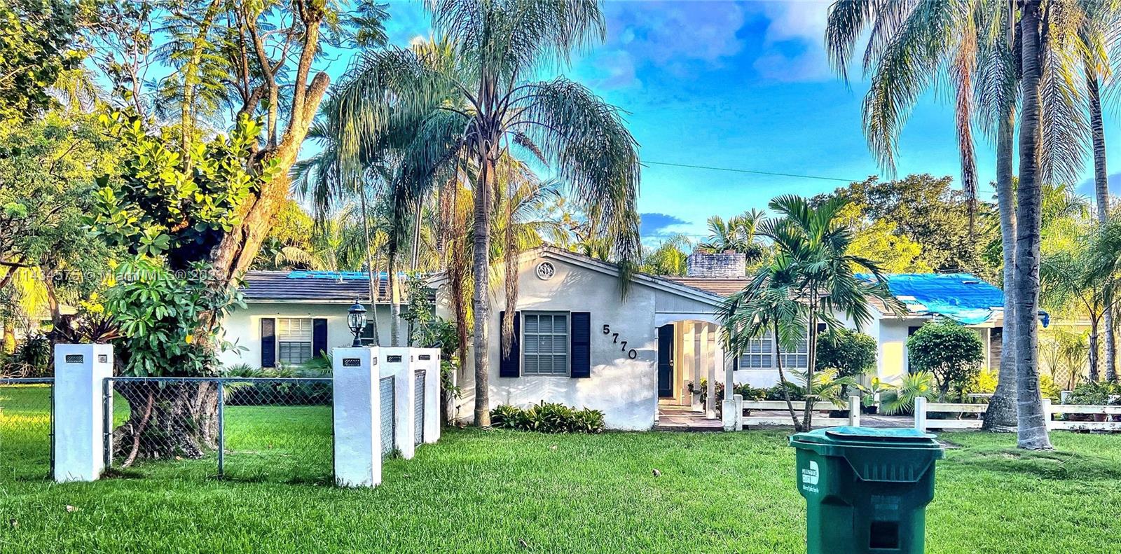 a front view of a house with a yard and green space