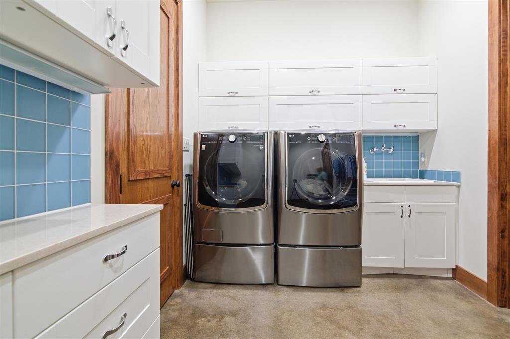 1138 Bancroft Road Keller, TX 76248 - Photo 22 of 39 Laundry area featuring white cabinetry, light countertops, blue tile backsplash, and wood trim details