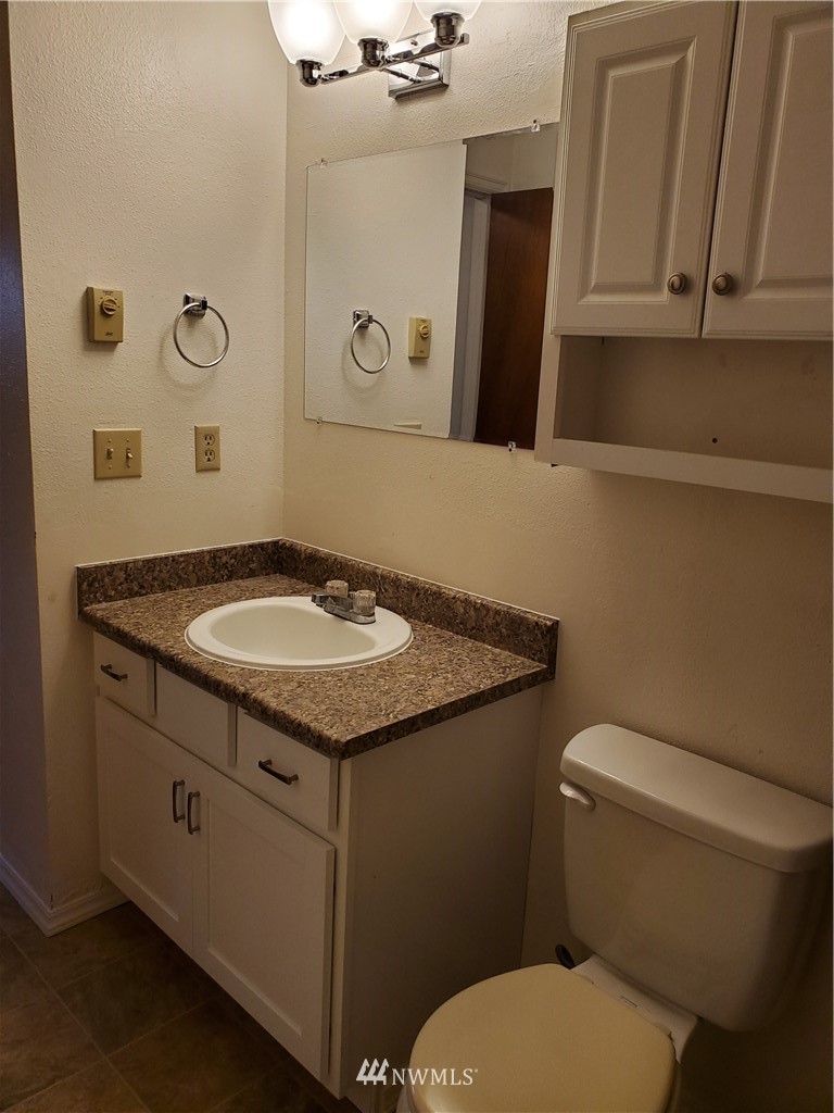 2728 Pine Road Northeast Bremerton, WA 98310 - Photo 12 of 21 a bathroom with a granite countertop toilet sink and mirror