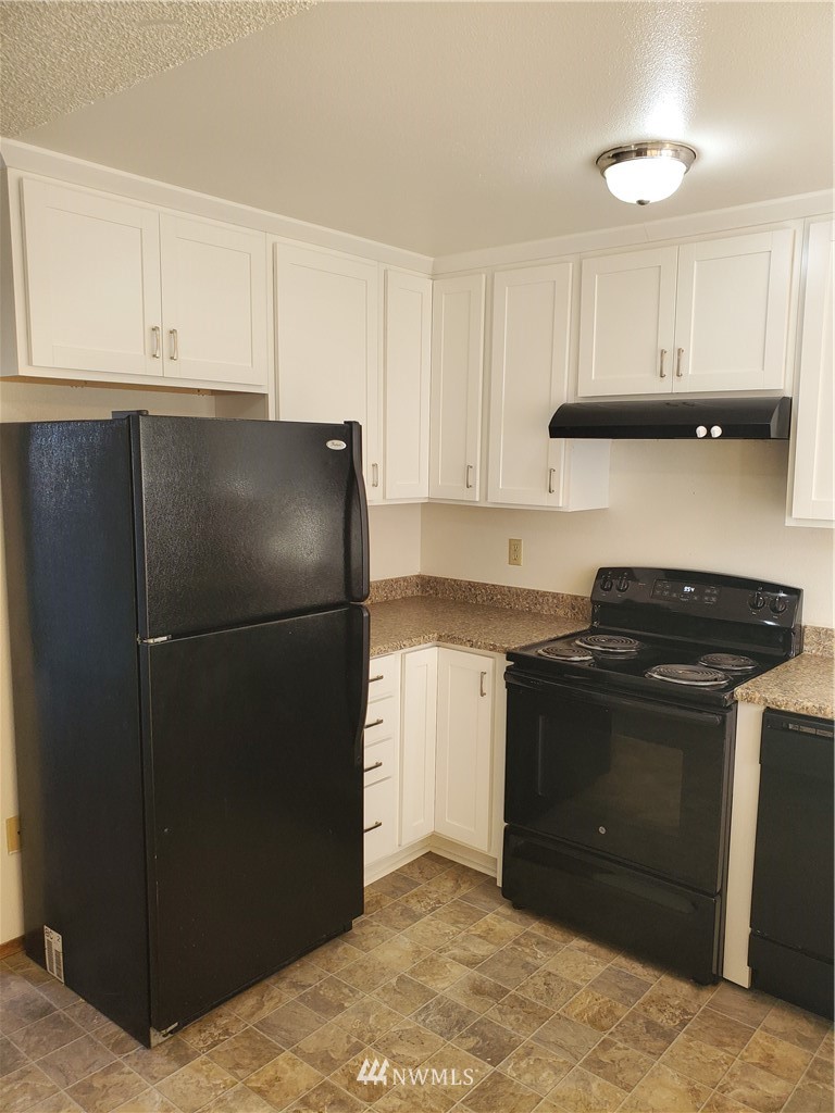 2728 Pine Road Northeast Bremerton, WA 98310 - Photo 16 of 21 a kitchen with a refrigerator and cabinets