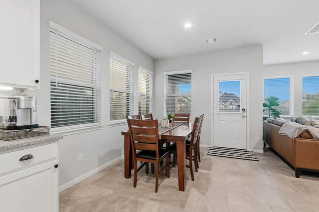a living room with stainless steel appliances furniture fireplace and a table