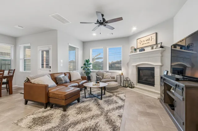 a living room with furniture a flat screen tv and a fireplace