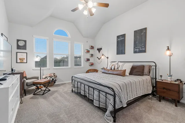 a bedroom with a bed and a flat tv screen on wall