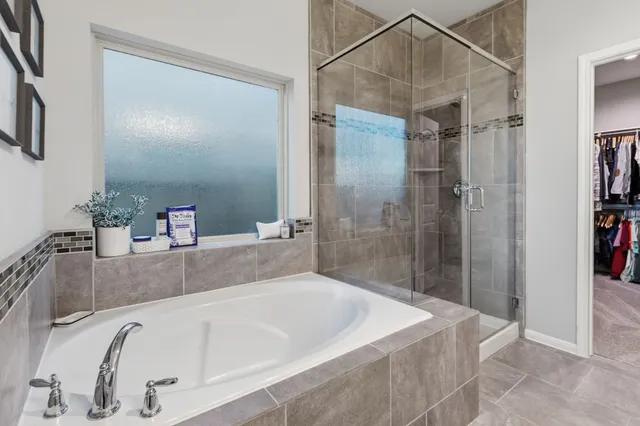 a spacious bathroom with a tub double sink and mirror