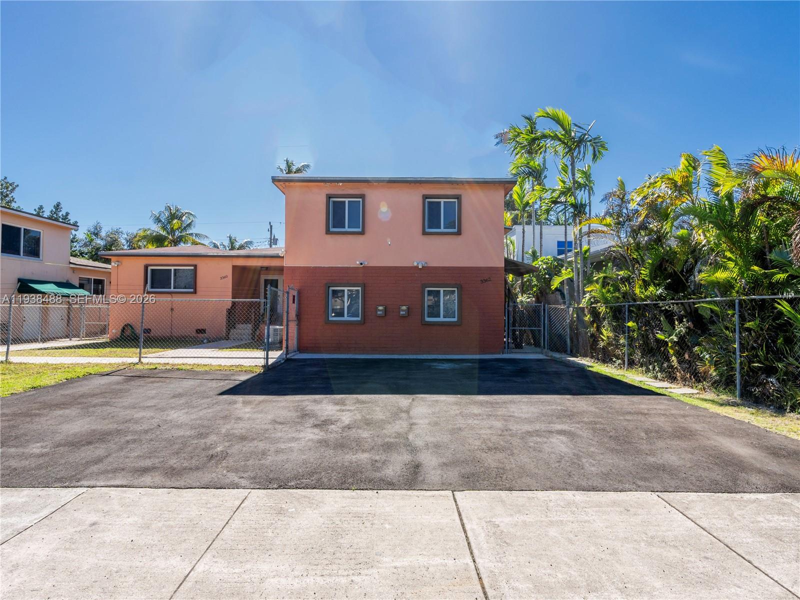 3360 Southwest 6th Street, Unit BOTTOM Miami, FL 33135 - Photo 1 of 17 a view of a house with a yard and a garage