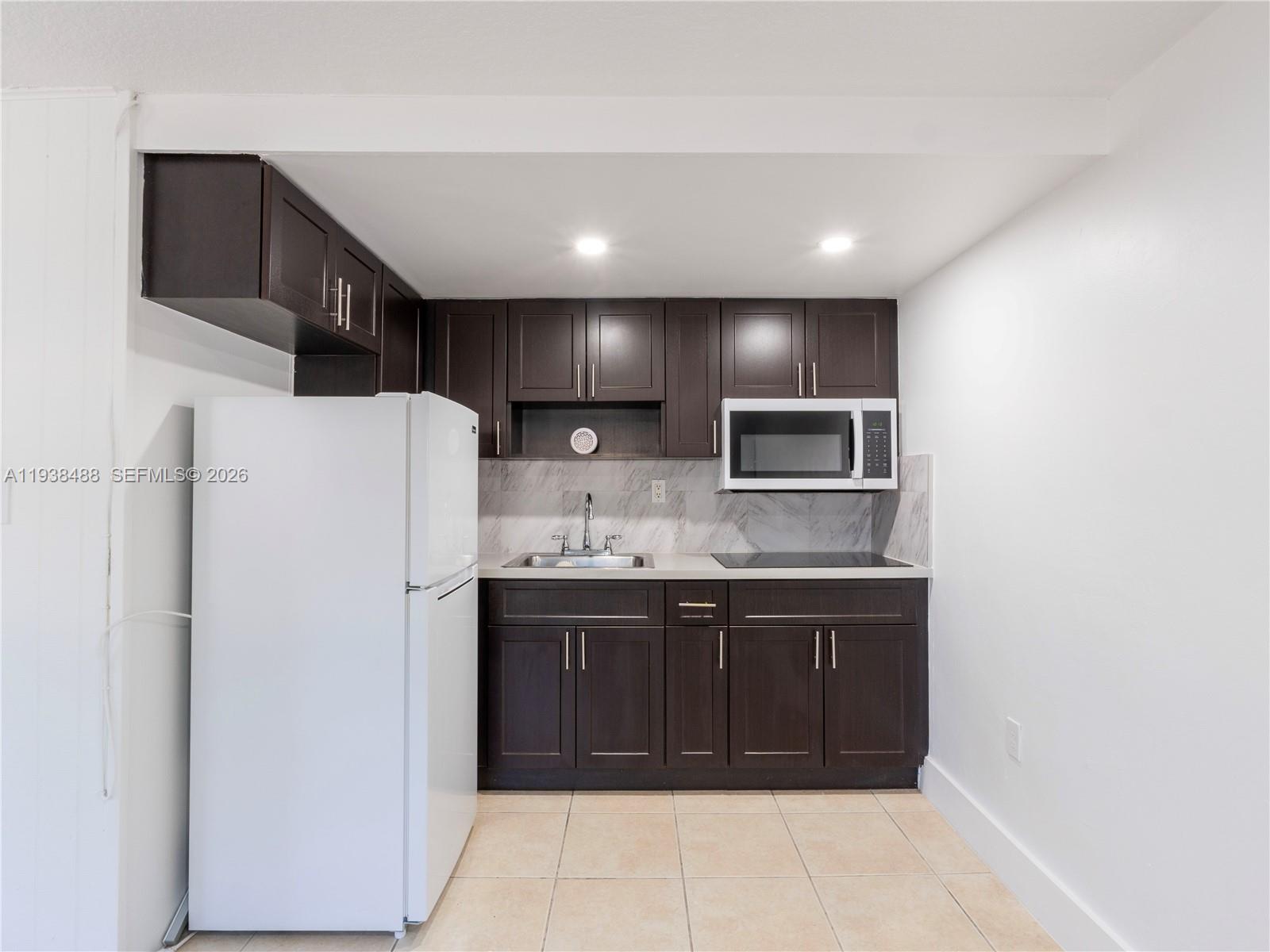 3360 Southwest 6th Street, Unit BOTTOM Miami, FL 33135 - Photo 7 of 17 a kitchen with stainless steel appliances granite countertop a refrigerator and a sink